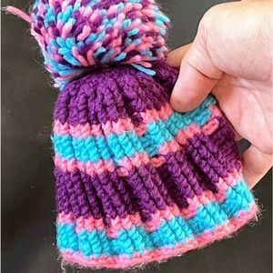 Very small turquoise, pink and purple baby pompom hat (6” wide)